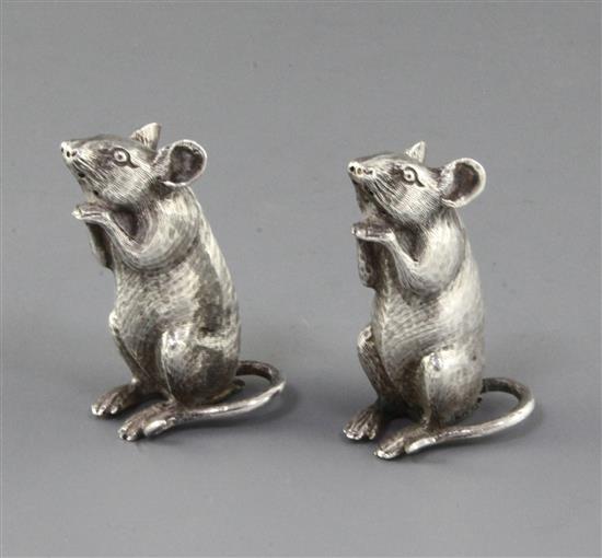 A pair of late Victorian novelty silver pepperettes by Saunders & Shepherd, each modelled as a seated rat, 2.25in.